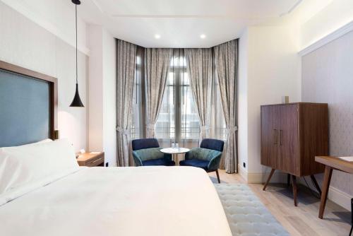 a hotel room with a bed and a table and chairs at DoubleTree by Hilton Madrid-Prado in Madrid