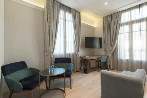 a living room with two chairs and a table at DoubleTree by Hilton Madrid-Prado in Madrid