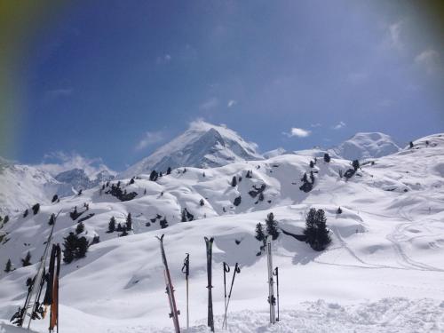 a snow covered mountain with skis in the foreground at A Larze in Le Châble