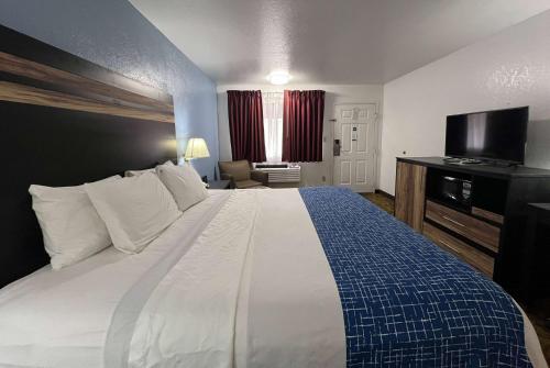 a hotel room with a bed and a television at Travelodge by Wyndham Truth or Consequences in Truth or Consequences