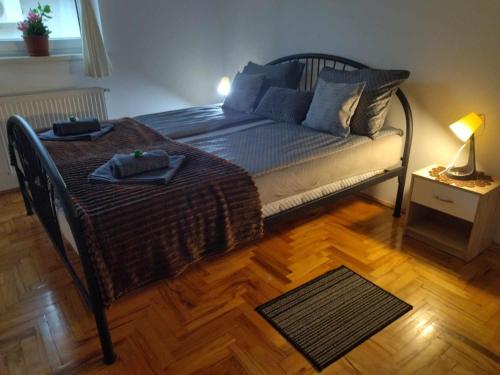 a bedroom with a bed with a table and a lamp at DORA Apartman in Palić