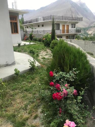 a house with pink flowers in the yard at Sonzal Hunza in Karimabad Hunza