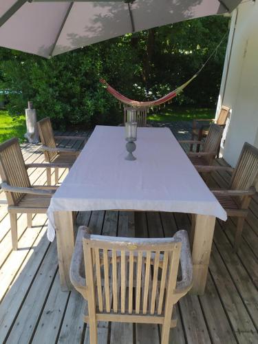 - une table avec des chaises et un parasol sur une terrasse dans l'établissement Maison avec piscine chauffée entre océan et bassin, à Lège-Cap-Ferret