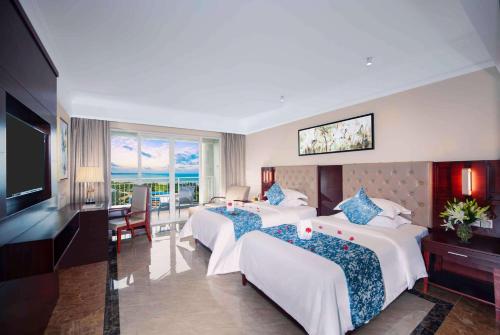 a hotel room with two beds and a television at Wyndham Garden Wenchang Nanguo in Wenchang