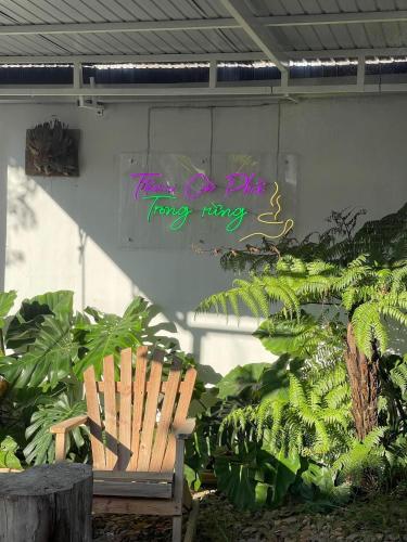 a bench in a garden with a sign on the wall at Retro Khe Sanh in Lao Bao