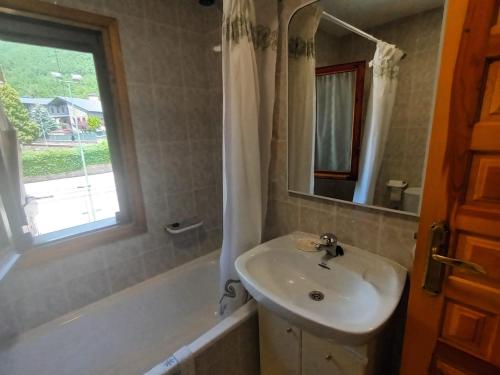 ガビンにあるApartamento EL PRADOの洗面台、鏡、浴槽のあるバスルーム