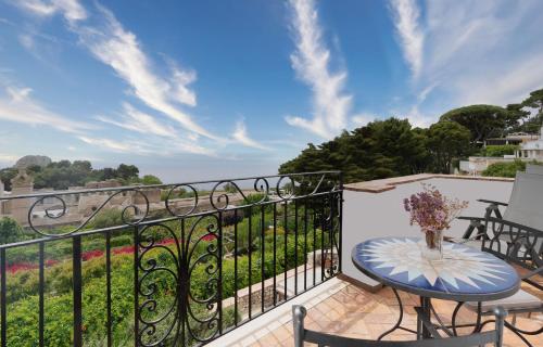 a balcony with a table and a view of the ocean at Sina Flora in Capri