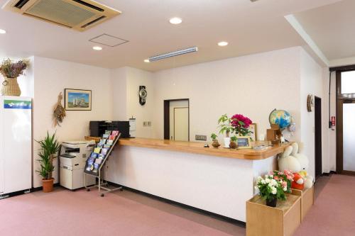 an empty waiting room with a counter and flowers at セミナープラザ　ロイヤルフジ in Fujikawaguchiko