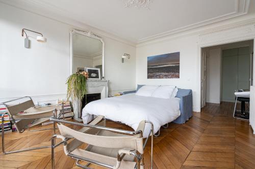 une chambre avec un lit, une table et des chaises dans l'établissement 2 bd lovely apt facing Canal St Martin sleeps 6, à Paris