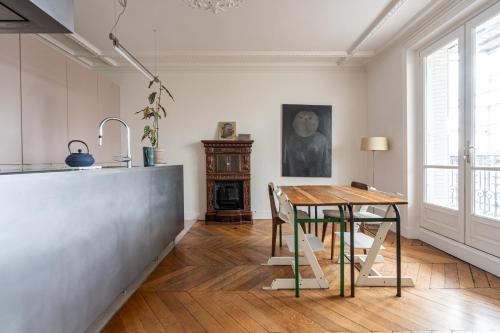 une cuisine avec une table en bois et une salle à manger dans l'établissement 2 bd lovely apt facing Canal St Martin sleeps 6, à Paris