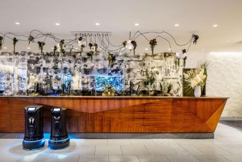 a bar in a restaurant with plants on the wall at Dream Hollywood, by Hyatt in Los Angeles