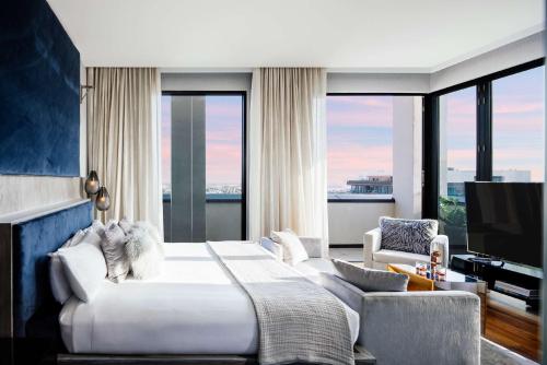 a bedroom with a large bed and a large window at Dream Hollywood, by Hyatt in Los Angeles