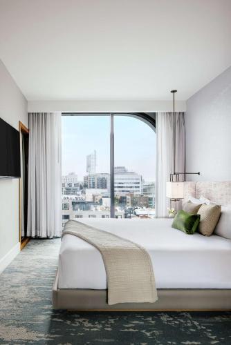 a bedroom with a large bed with a large window at Dream Hollywood, by Hyatt in Los Angeles