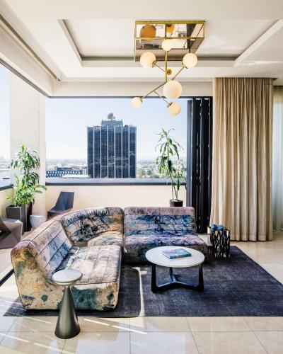 a living room with a couch and a table at Dream Hollywood, by Hyatt in Los Angeles
