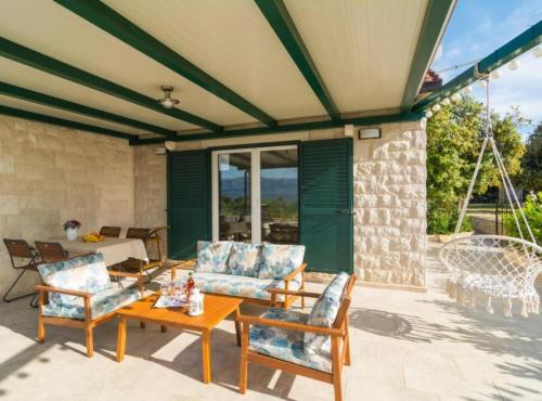 a patio with couches and a table and chairs at Holiday home Blato in Postira