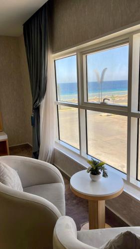 a living room with a view of the beach at Rose Land Hotel in Umm Lujj