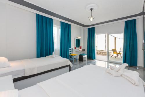 Dos camas en una habitación con cortinas azules. en Villa Riveria, en Kas