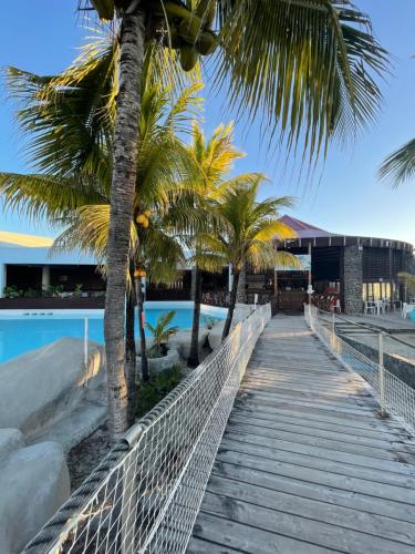 a boardwalk leading to the beach with palm trees at Studio 25 m Manganao Joela 4 personnes avec machine a laver in Saint-François