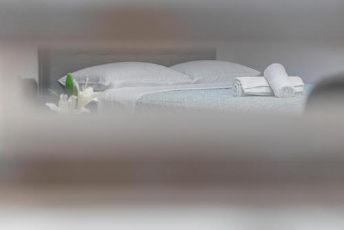 a white bed with two towels and flowers on it at Niki's Apartments in Faraí