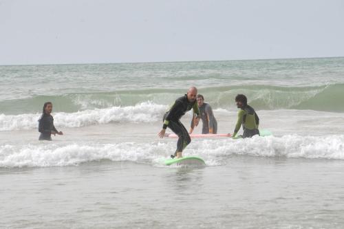 a man riding a wave on a surfboard in the ocean at Anza surfhouse in Agadir