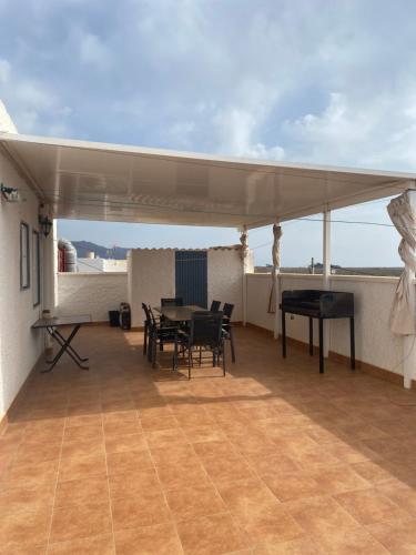 Un patio con una mesa y sillas en un tejado. en Casa Pepe, en Níjar