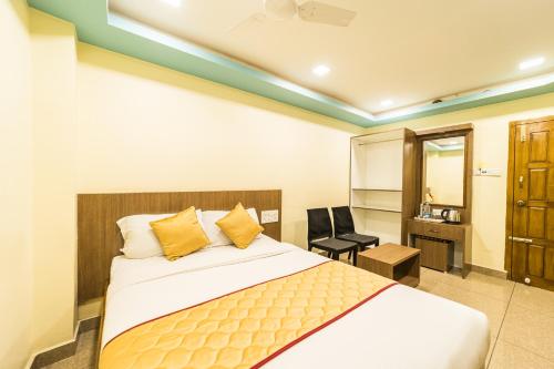 a bedroom with a bed and a desk and a chair at SAU Residency in Kanchipuram