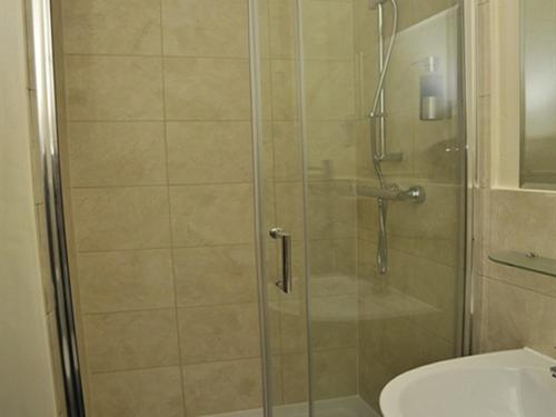 ducha con puerta de cristal junto a un aseo en Hoppers Cottage Guest House en Gateshead