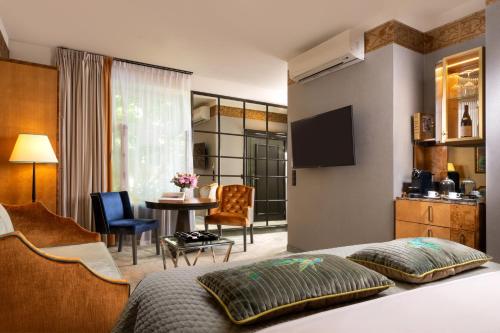 a hotel room with a bed and a dining room at Balthazar Design Hotel in Kraków