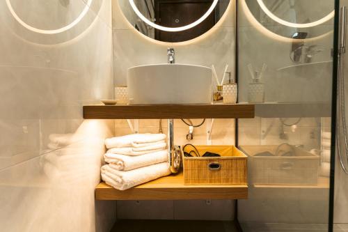 a bathroom with a shelf with towels and a sink at Casa Evanti in Syvota