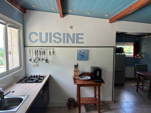 une cuisine avec un panneau de cuisine sur le mur dans l'établissement La Pierre rouge, à Floressas