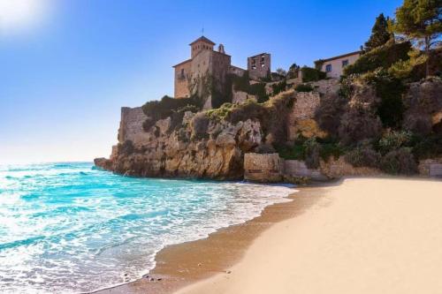 a beach with a castle on top of a mountain at Apartamento altafullaplatja in Altafulla
