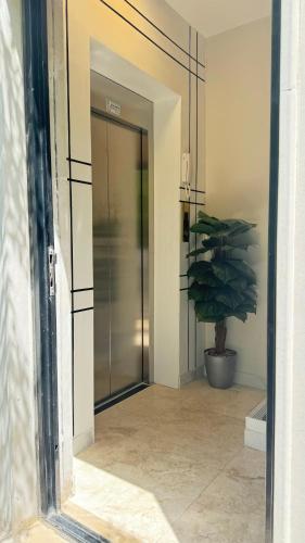 an open door to a hallway with a potted plant at Neem Luxury Apartment C in Al Fanātīr