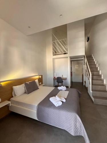 a bedroom with a large bed and a staircase at Villa Hara Suites in Paralia Katerinis