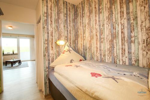 a bedroom with a bed with a floral wallpaper at Haus Nautic Döse Wohnung 123 in Cuxhaven