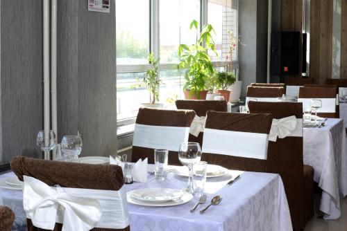 a dining room with white tables and chairs and a window at Zolo Hotel in Ulaanbaatar