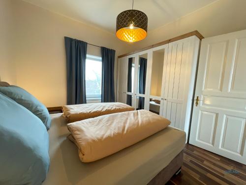 a bedroom with a bed and a large window at Strandbude 2 Döse in Cuxhaven