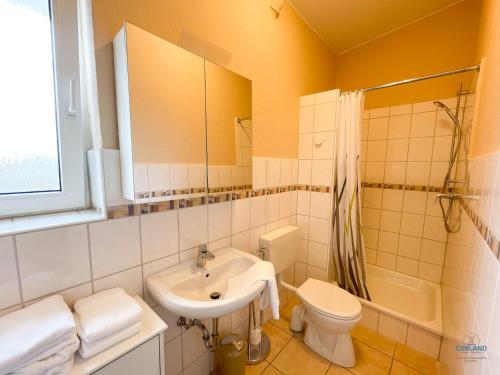 a white bathroom with a sink and a toilet at Strandbude 2 Döse in Cuxhaven