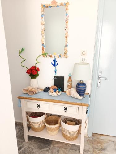a console table with baskets and a mirror at Massouri Rooms in Masouri