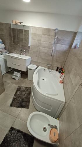 a bathroom with a tub and a toilet and a sink at Steffi Apartment in Balş