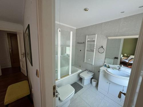 a bathroom with a toilet and a tub and a sink at Casa rural y moderna in Hondarribia