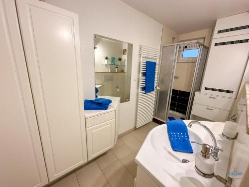 a white bathroom with a sink and a mirror at Haus Nautic Döse Wohnung 214 in Cuxhaven