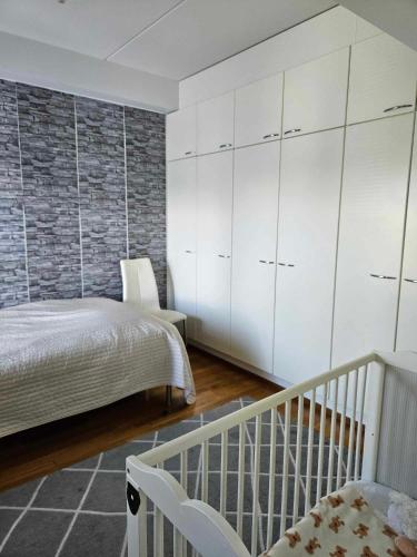 a bedroom with a bed and a white cabinet at Uniq Home Helsinki in Helsinki