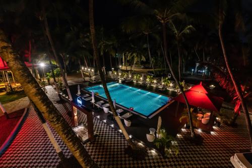 an overhead view of a swimming pool at night at The Woodside Inn in Benaulim