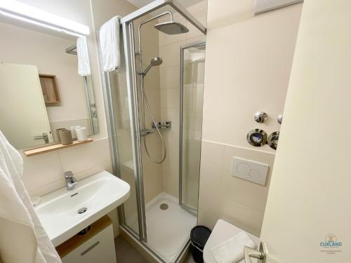 a bathroom with a shower and a sink at Whg. 121 Haus Jan am Strand in Cuxhaven