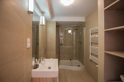 a bathroom with a sink and a shower and a tub at Apartview Bukowa III by Rent like home in Wisła