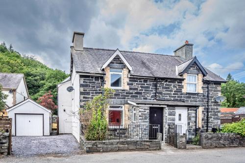 an old stone house with a white garage at Finest Retreats - Blaen Ddol in Betws-y-coed