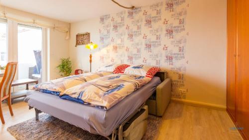 a bedroom with a bed and a wall with drawings at Urlaub mit Seesicht Haus Nautic Whg. 201 in Cuxhaven