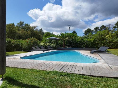 une piscine avec des chaises et un parasol dans l'établissement Villa Katiris, à Porto-Vecchio