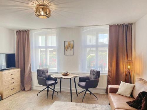 a living room with a table and chairs and a couch at Hofstelle No1- Erpel in Lübbenau