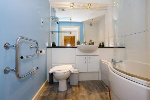 a bathroom with a toilet and a sink and a tub at Lovely 2 Bed 2 Bathroom Apartment Manchester in Manchester